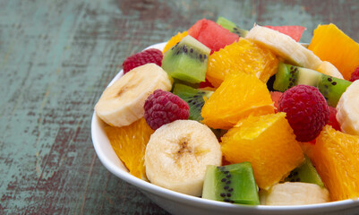 fresh healthy fruit salad on wooden background