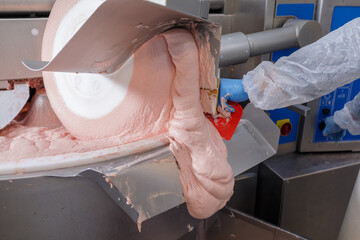 Processing meat in a huge meat grinder for sausages in a meat processing plant close-up, the...