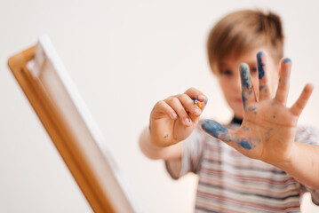 The boy draws a picture by numbers. Hand paints color