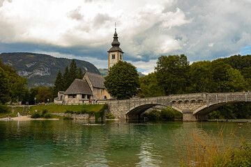Fototapeta na wymiar Bohinj lake bridge and church of St. John the Baptist in Ribčev Laz in Slovenia