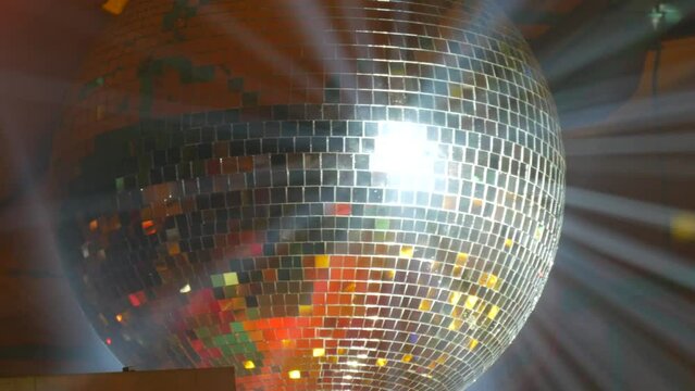 Silver mirror disco ball at a party or celebration. Lighting design on the stage of the birthday party in the club. Abstract background of retro disco ball
