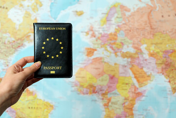 European Union passport in front of world map.