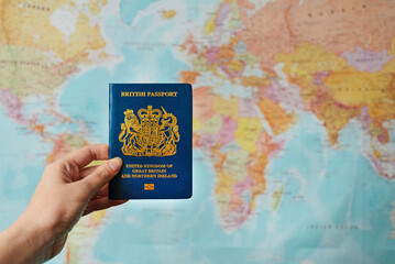 United Kingdom of Great Britain passport in front of world map.