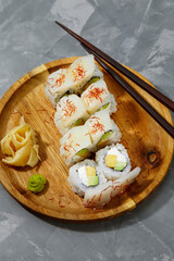 set of rolls on a round wooden board on a gray background