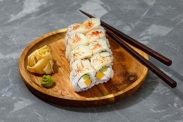 set of rolls on a round wooden board on a gray background