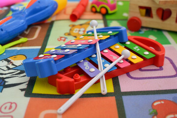2 xylophones in red and blue on a background of a children's carpet
