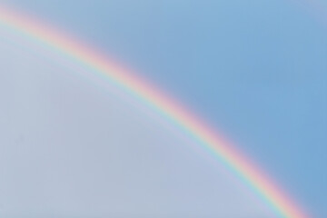 Beautiful colored rainbow in the blue cloudy sky