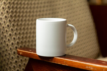 White mug on the armrest of a chair - 532280687