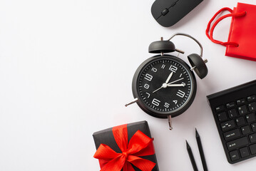 Cyber monday concept. Top view photo of giftbox with ribbon bow alarm clock computer mouse keyboard pencils and red paper bag on isolated white background with copyspace