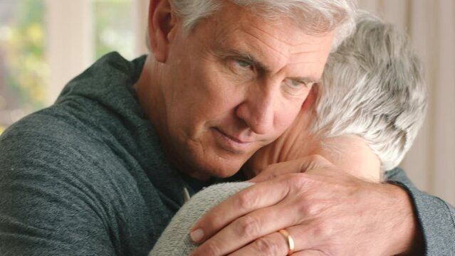 Retirement, Marriage Couple And A Sad Hug For Support And Comfort With Emotional News In House. Elderly Man Holding Depressed Wife To Express Love And Care For Her Grief In Nursing Home.