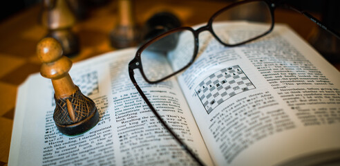 Self studying chess from a book, wooden chessboard and chess pieces