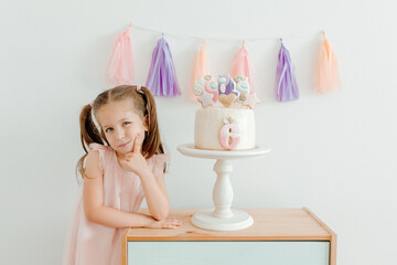 Cute little girl in pink dress with bithday cake. Six years old celebration. Birthday decoration