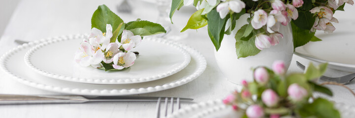 Beautiful table decor for a wedding dinner with a spring blooming apple tree flowers. Celebration...
