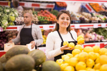 hispanic man and woman wearing uniform and working together in supermarket