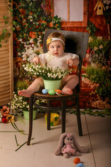 portrait girl one year old shooting in studio sitting on wooden chair snowdrops background flowers 