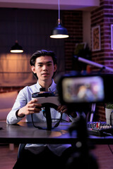 Content creator doing vr glasses review on camera, recording online video and talking about virtual reality headset. Broadcasting product recommendation vlog on live podcast show.