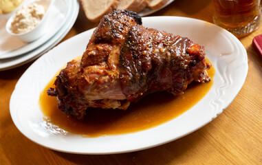 Appetizing pork knuckle baked in oven with mustard, spicy horseradish and bread. Typical czech dish