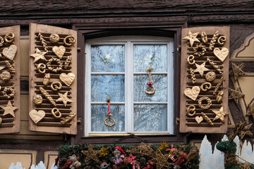 Colmar, France. Old town Colmar adorned with Christmas decoration. Shutters are adorned with homemade hearts, stars, pretzels and pies.