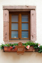 Riquewihr, France. Village established in the 1400's in the Alsace Region. Window decorated with Christmas ornaments.