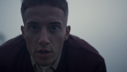 Active man running sea beach in morning. Exhausted guy stopping after run 