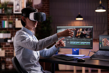 Male videographer editing movie montage with virtual reality glasses, using multimedia production...