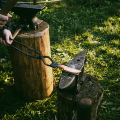 Forging a knife in an open-air blacksmith's workshop.