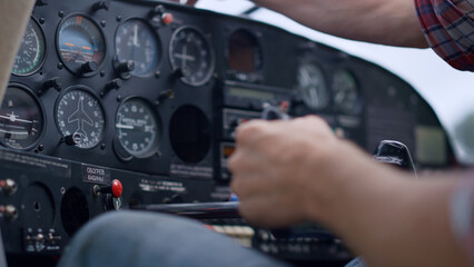 Hand airman driving airplane checking indicators control panel close up.