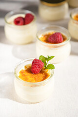 French dessert custard creme brulee with caramel crust, garnished with fresh berries. Traditional cuisine. Vertical photo