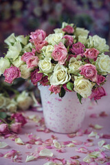 Beautiful fresh roses in a cup on a pink background
