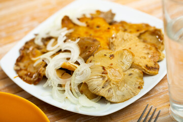 Delicious pickled russula delica, sprinkled with onion rings on top - obrazy, fototapety, plakaty