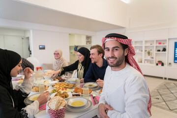 young arabian man having Iftar dinner with muslim family Eating traditional food during Ramadan feasting month at home. The Islamic Halal Eating and Drinking Islamic family