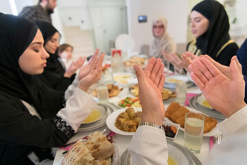 Muslim family making iftar dua to break fasting during Ramadan.