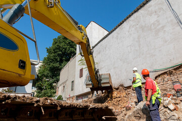 Process of demolition of old building dismantling. Excavator breaking house. Destruction of...