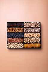 Hazelnuts, almonds, raisins, dried apricots, peanuts, cashews, pistachios in a box.