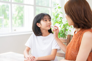 お母さんに化粧をしてもらう女の子