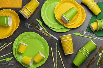 Flat lay composition with disposable tableware on dark grey background