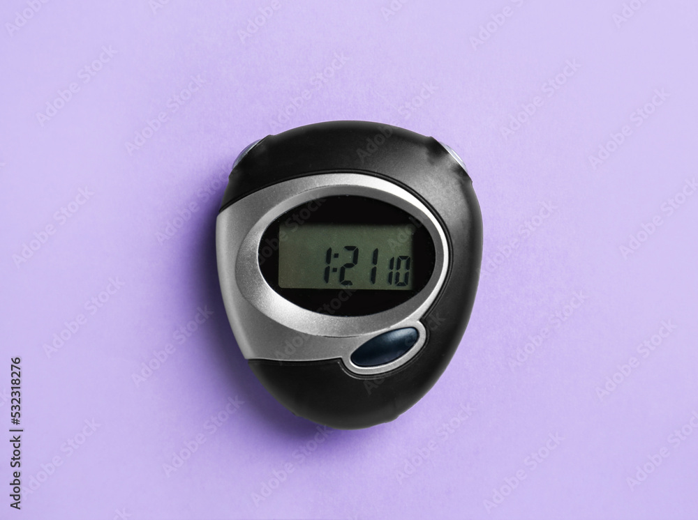 Wall mural Digital timer on violet background, top view