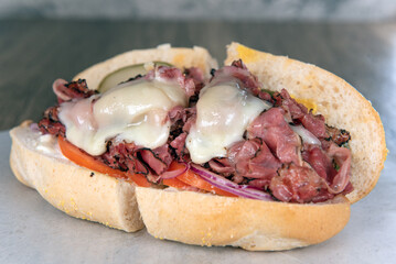Lunch is served with a loaded pastrami sub sandwich overflowing with melted cheese