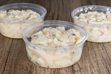 Lunch is complimented with a variety of side orders consisting of macaroni, potato, or German Potato salad in resuable containers - obrazy, fototapety, plakaty