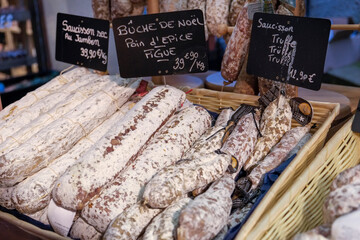 Riquewihr, France. Local market selling sausages with truffles, dried ham and Christmas cake.
