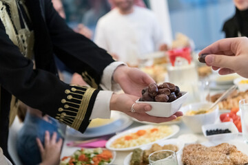 modern multiethnic muslim family sharing a bowl of dates while enjoying iftar dinner together during a ramadan feast at home