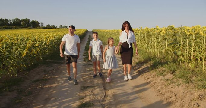 A happy family with two children is walking in nature