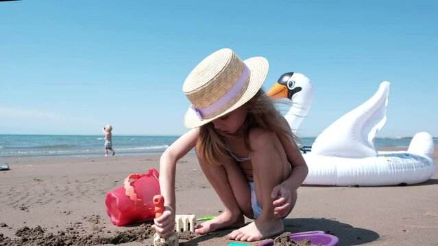 little girl playing with sand on the beach