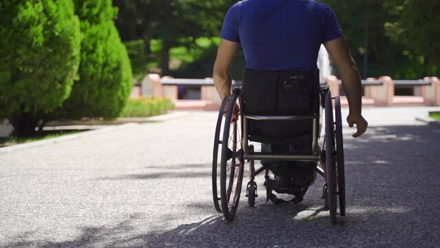 Disabled man driving his wheelchair outdoors in slow motion.
Man with physical disability drives his wheelchair in slow motion.
