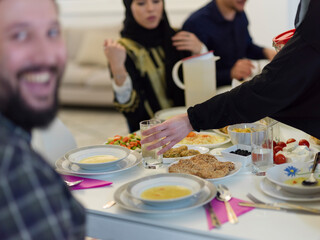 Muslim family making iftar dua to break fasting during Ramadan.