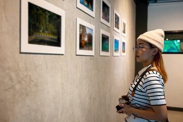 Photographer visit at photo frame to leaning against at show exhibit artwork gallery, Asian woman...