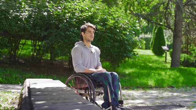 Frustrated disabled teenager sitting in wheelchair in slow motion.
Frustrated disabled teenager sitting in wheelchair.
