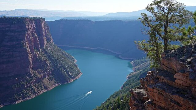 Flaming Gorge with boat in the Green River at Red Canyon overlook on sunny day in Utah.