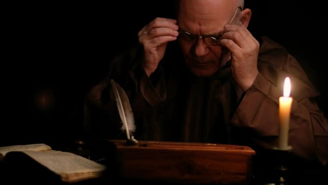 Video of old monk takes a manuscript out of the document box, signs it, wet paperweight, and puts it back.