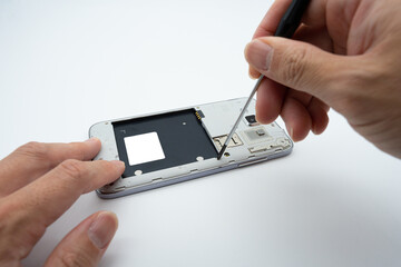 The situation of repairing a cell phone using a screwdriver tool